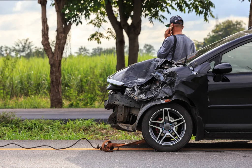 Man lying by a car after a hit-and-run accident.